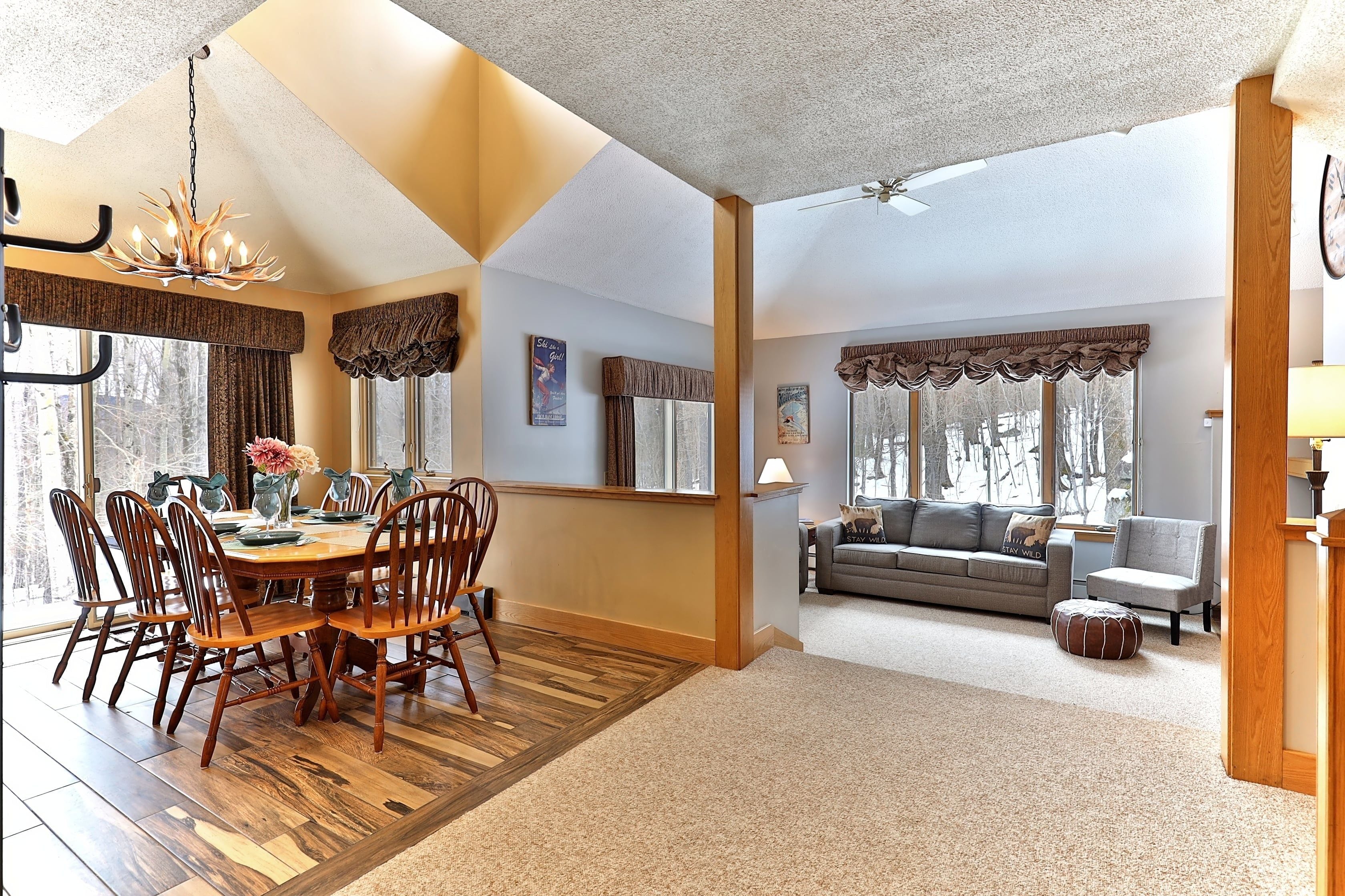 A spacious living area with a dining table, chairs, and a sofa.
