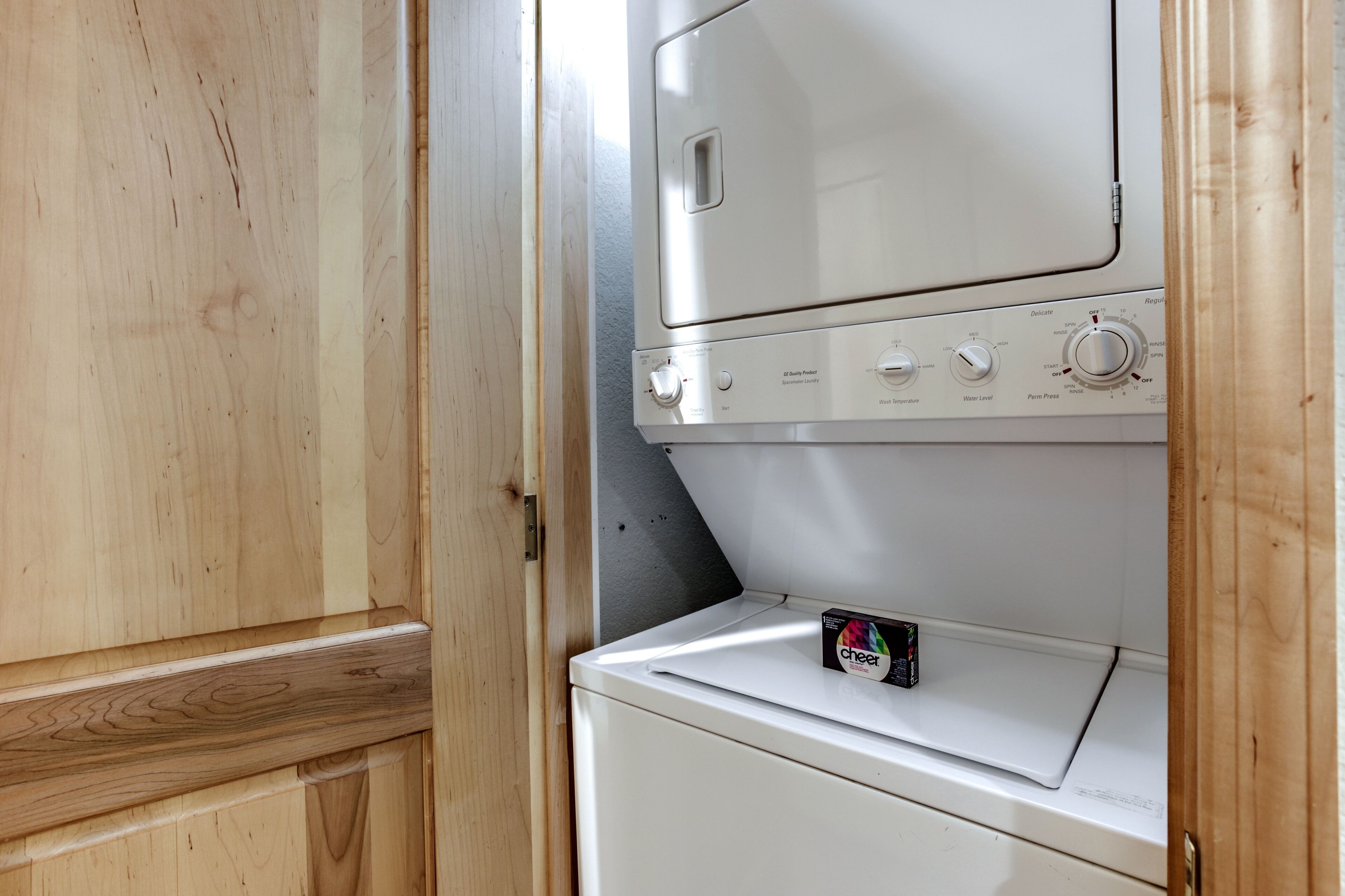 A white washer and dryer unit with a control panel and a sticker on the dryer.