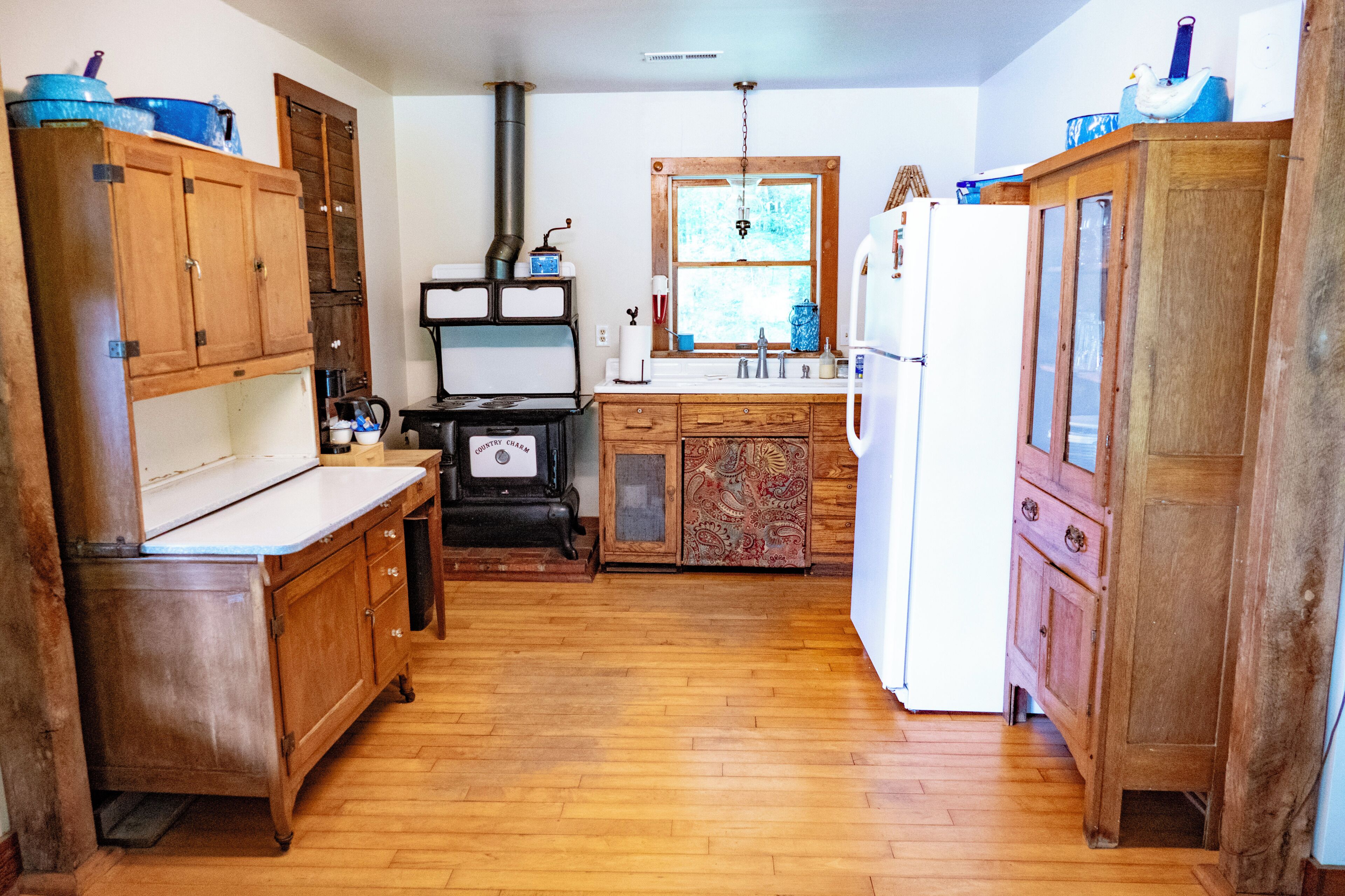Une cuisine avec des meubles de rangement en bois, une cuisinière et un réfrigérateur.