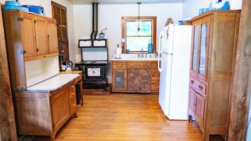 Une cuisine avec des meubles de rangement en bois, une cuisinière et un réfrigérateur.