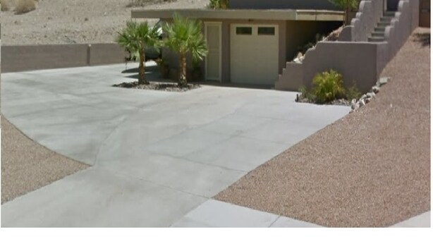 A spacious concrete driveway leading to a building with a small entrance and a staircase. - Quite studio with RV parking (Lake Havasu City)