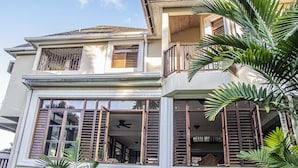 A two-story house with a balcony, large windows, and a ceiling fan. - Villa Belle Abri (Montego Bay)