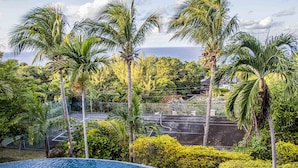 A pool surrounded by palm trees and a tennis court. - Villa Belle Abri (Montego Bay)