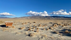 A desert landscape with a sign indicating the Olancha Dunes. - Olancha Lakeside Camping RV Site#2 Near Mt. Whitney (Olancha)