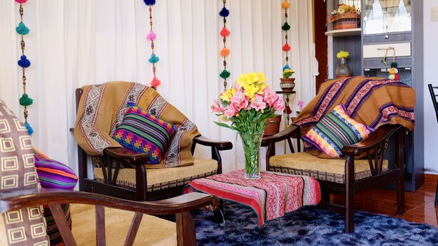 A cozy seating area with two chairs, a small table, and a vase of flowers. - COZY & BEAUTIFUL APART IN SAN BLAS CUSCO (Cusco)