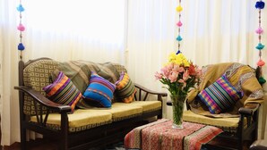 A traditional sofa with patterned cushions, a matching ottoman, and a vase of flowers. - COZY & BEAUTIFUL APART IN SAN BLAS CUSCO (Cusco)