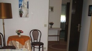 A hotel room with two beds, a table with a vase of flowers, a chair, and a painting on the wall. - Spacious,comfortable apartment,150m2, first floor,quiet,garden-side with terrace (Wien)