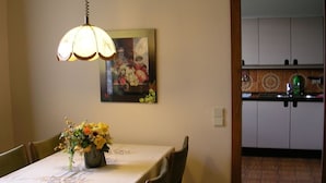 A dining area with a table set for two, a vase of flowers, and a painting on the wall. - Spacious,comfortable apartment,150m2, first floor,quiet,garden-side with terrace (Wien)