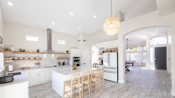 A spacious kitchen with a large island, white cabinetry, and a modern pendant light. - Fun Filled Stadium Getaway w/ Heated Pool & Golf (Glendale)