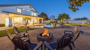 A modern house with a swimming pool, outdoor seating, and a fire pit. - Fun Filled Stadium Getaway w/ Heated Pool & Golf (Glendale)