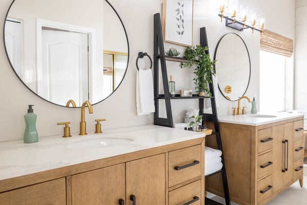 Une salle de bain moderne avec deux vasques, un grand miroir et un meuble-lavabo en bois.