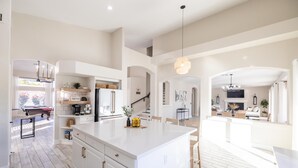 A spacious kitchen with a central island, built-in appliances, and a dining area with a view. - Fun Filled Stadium Getaway w/ Heated Pool & Golf (Glendale)