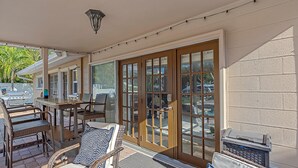 Un patio exterior con una parrilla, sillas y una mesa.