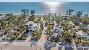 Vista aérea de una zona residencial costera con casas, una playa y una vista despejada del océano.