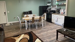 A modern living room with a dining area, kitchen, and a TV on a stand. - New Near Jamestown Dock - A (Jamestown)