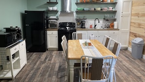 A compact kitchen with a dining area, featuring a refrigerator, stove, microwave, and various kitchen appliances. - New Near Jamestown Dock - A (Jamestown)