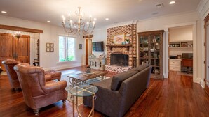 A spacious living room with a brick fireplace, leather armchairs, a glass coffee table, and a chandelier. - Spacious, serene retreat perfect for Oxford visits<br>New listing!!  (Oxford)
