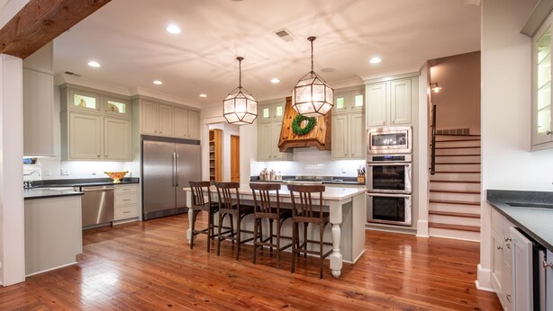 A spacious kitchen with wooden flooring, white cabinetry, a central island with bar stools, a stainless steel refrigerator, a microwave, and an oven. - Spacious, serene retreat perfect for Oxford visits<br>New listing!!  (Oxford)