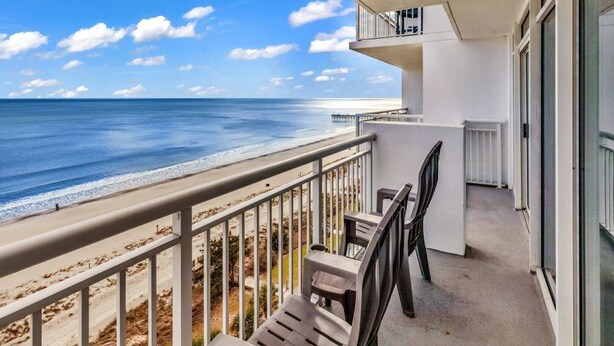 Een balkon met uitzicht op het strand en de oceaan.