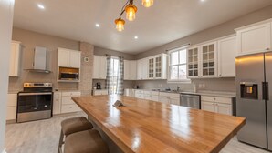 A modern kitchen with a central island, stainless steel appliances, and white cabinetry.