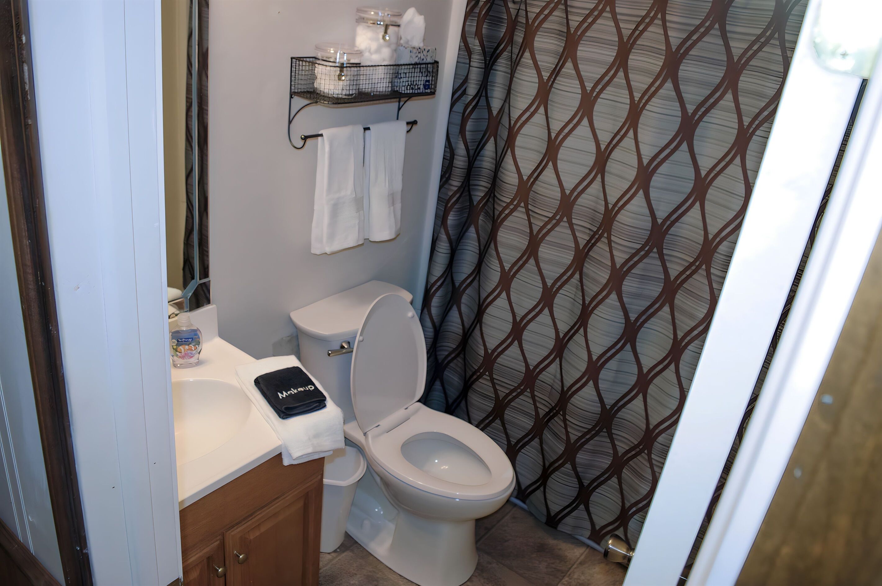 A bathroom with a toilet, sink, and shower curtain.