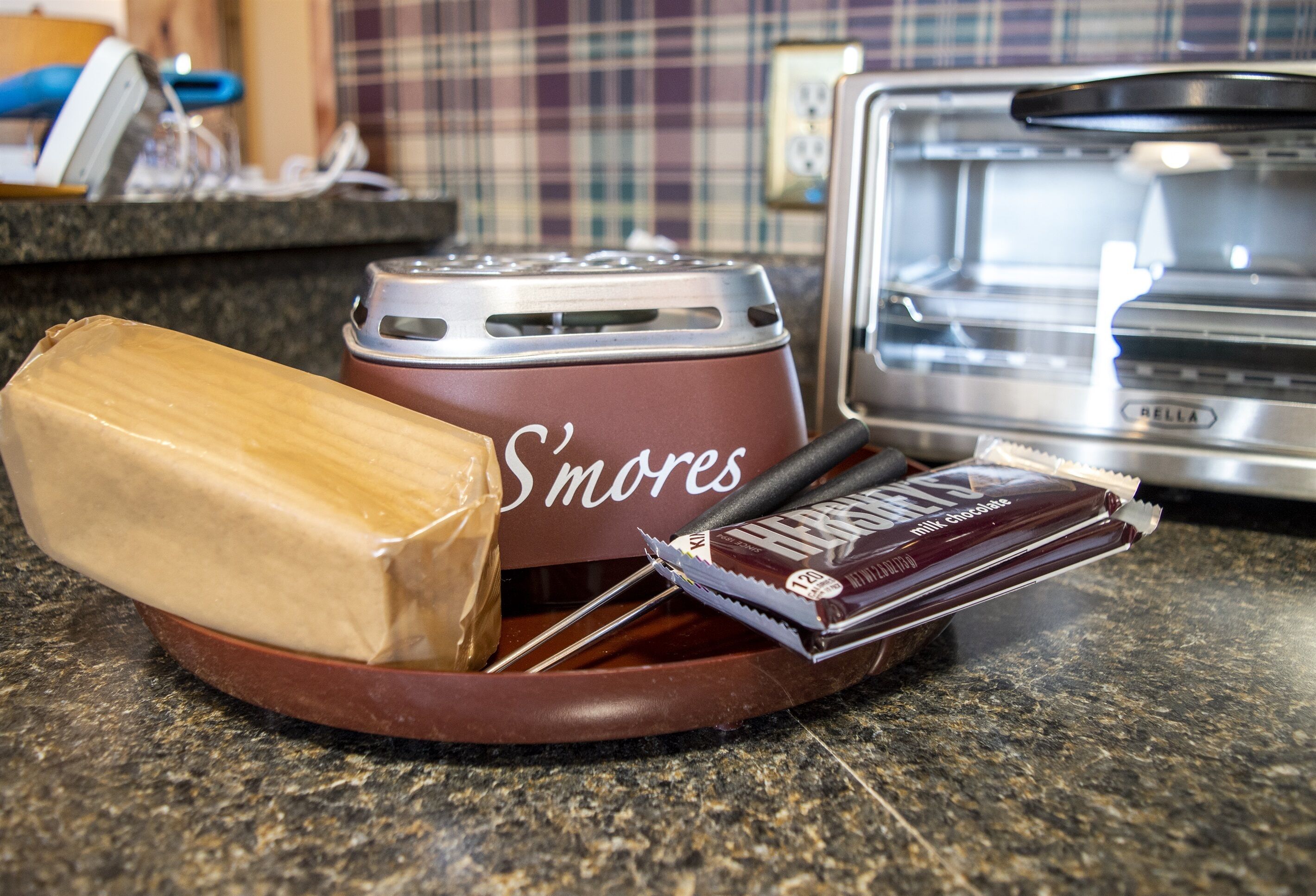 A kitchen counter with a S'mores kit, including a marshmallow, chocolate, and a lighter.