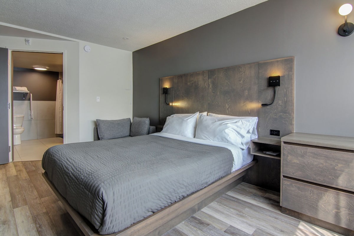 Une chambre moderne avec un lit, des tables de chevet et une armoire intégrée.
