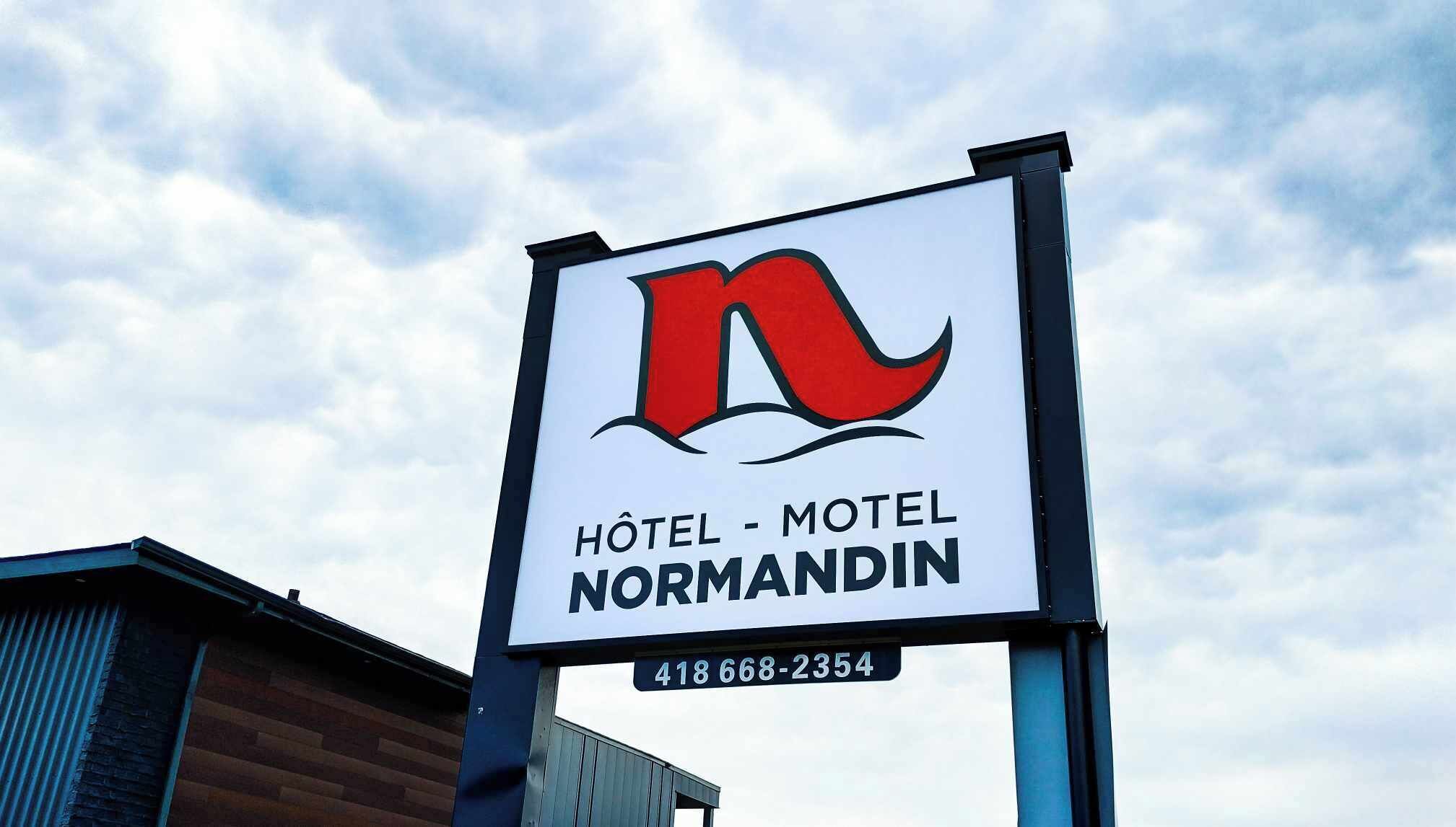 Letrero del Hotel - Motel Normandin con logotipo y número de contacto.