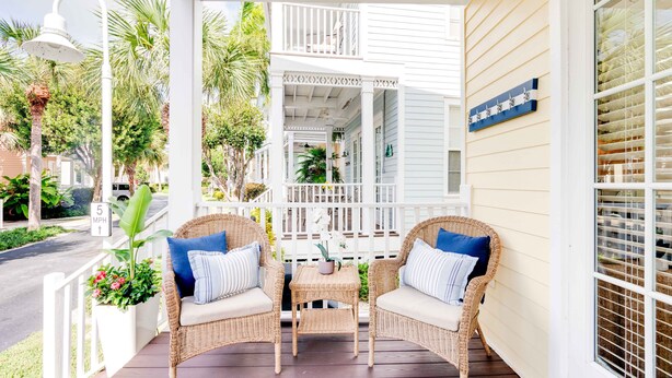 A porch with wicker furniture and a small table, surrounded by white railings and plants. - 4 Bedroom House in Angler's Reef, Includes 31' Boat Slip. Islamorada, FL (Islamorada)