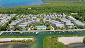 An aerial view of a resort with multiple buildings, a central pool, and a marina. - 4 Bedroom House in Angler's Reef, Includes 31' Boat Slip. Islamorada, FL (Islamorada)