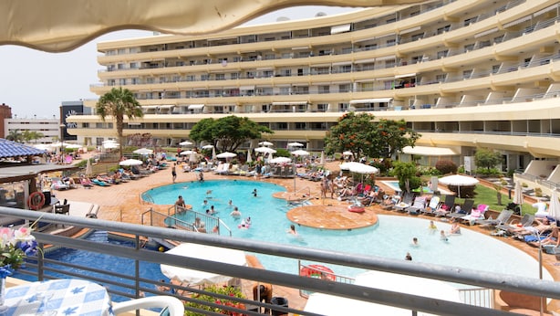 A hotel with a large pool area, multiple balconies, and outdoor seating. - 2 Bed Hotel Apt. Sleeps 3/4, Five minutes walk to Beach, Shops & Restaurants  (Costa Adeje)