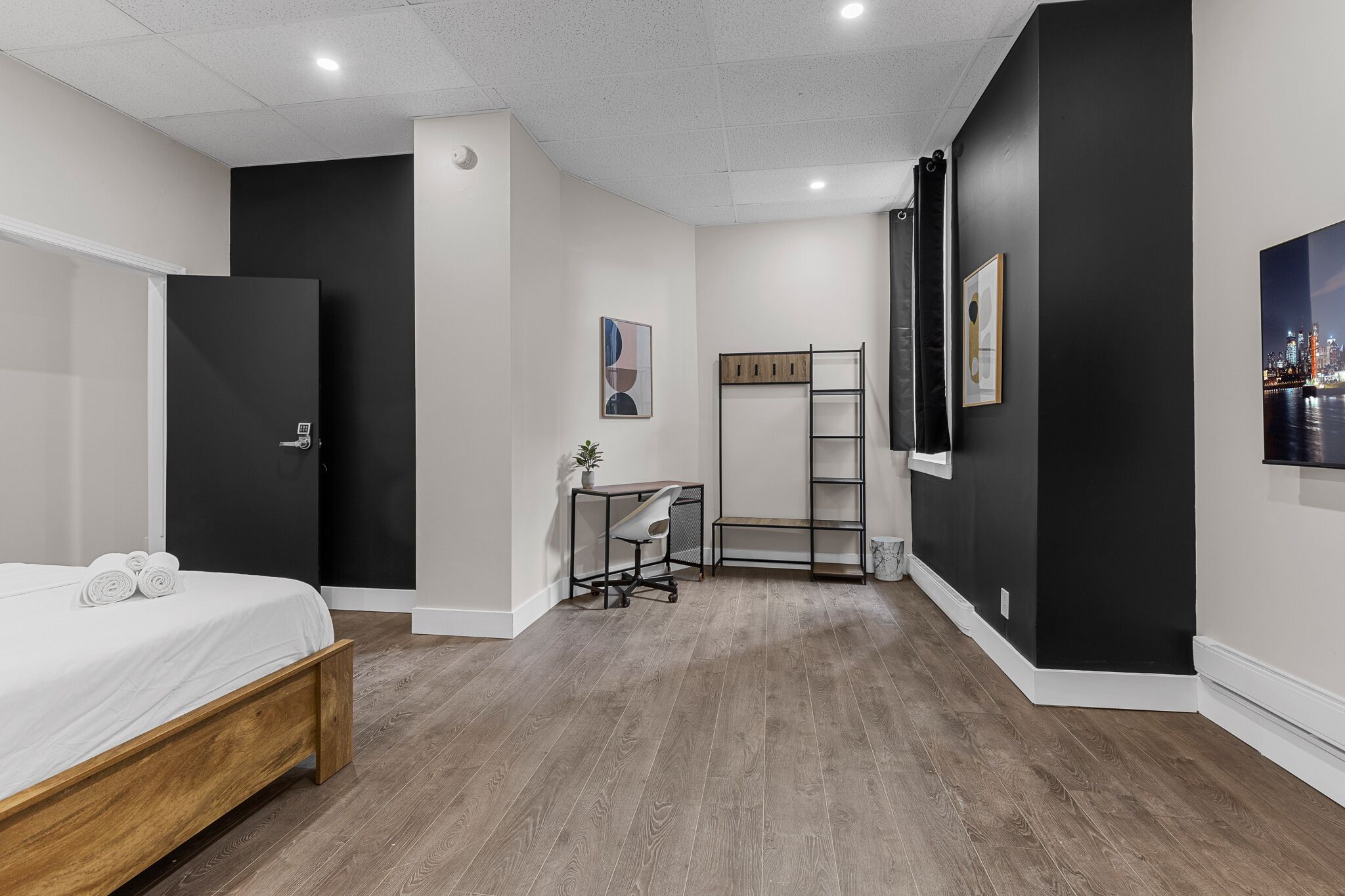 Quarto de hotel moderno com cama, escrivaninha e vista para a cidade.