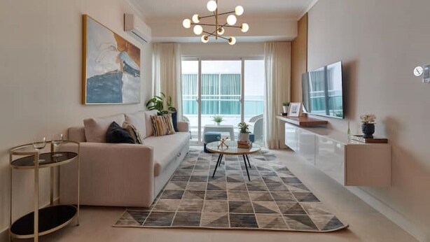 A modern living room with a sofa, coffee table, and artwork on the wall.