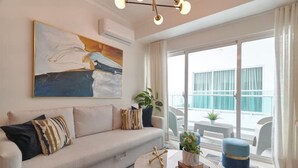 A modern living room with a sofa, a coffee table, and a painting on the wall.