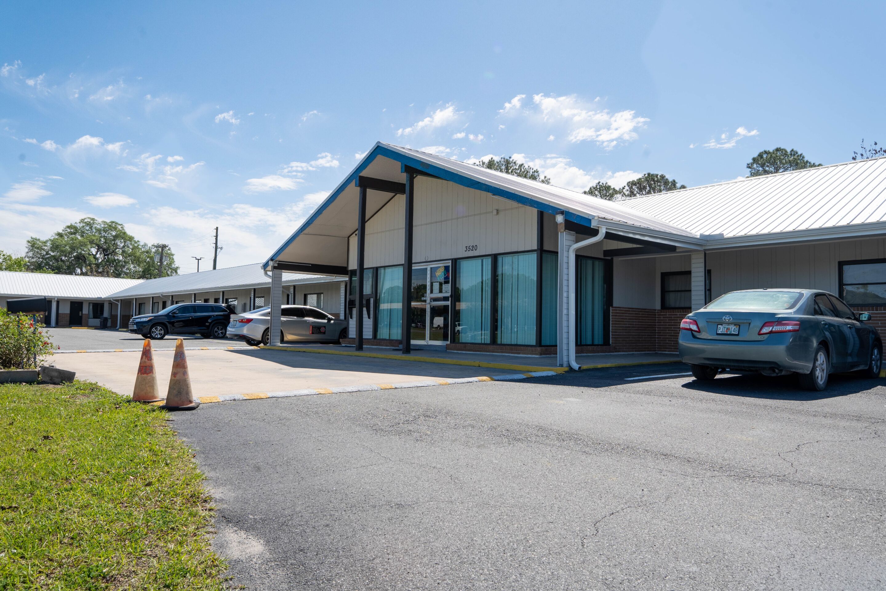 A modern building with a covered entrance and a parking lot.