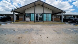 A motel with a covered parking area, a brick facade, and a sign indicating the number 3520. - OYO Hotel Ocala, Fl I-75 (Ocala)