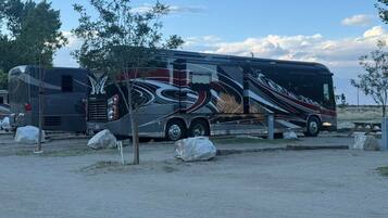 A large RV parked in a lot with a distinctive black and red design.