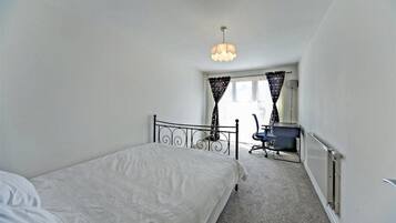 2 habitaciones, escritorio y tabla de planchar con plancha