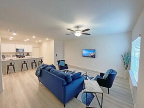 Relax in this stylish living space with a sofa, dining table, and flat-screen TV.