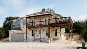 A two-story house with a stone facade, a covered porch, and a garage.