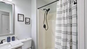 A bathroom with a shower, toilet, and sink.