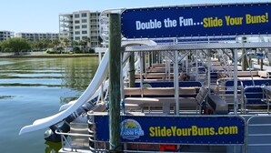 A boat with a sign advertising 'Slide Your Buns' and a website 'SlideYourBuns.com'. - Remodeled Beachfront 🐠🦀 Destin West's Best 😎😎 Beach Service Inc ⛱️⛱️NEW EVERYTHING (Fort Walton Beach)