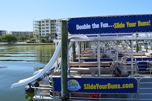 A boat with a sign advertising "Double the Fun...Slide Your Buns!" and a website address "SlideYourBuns.com". - Remodeled Beachfront π π¦ Destin West's Best ππ Beach Service Inc β±οΈβ±οΈNEW EVERYTHING (Fort Walton Beach)
