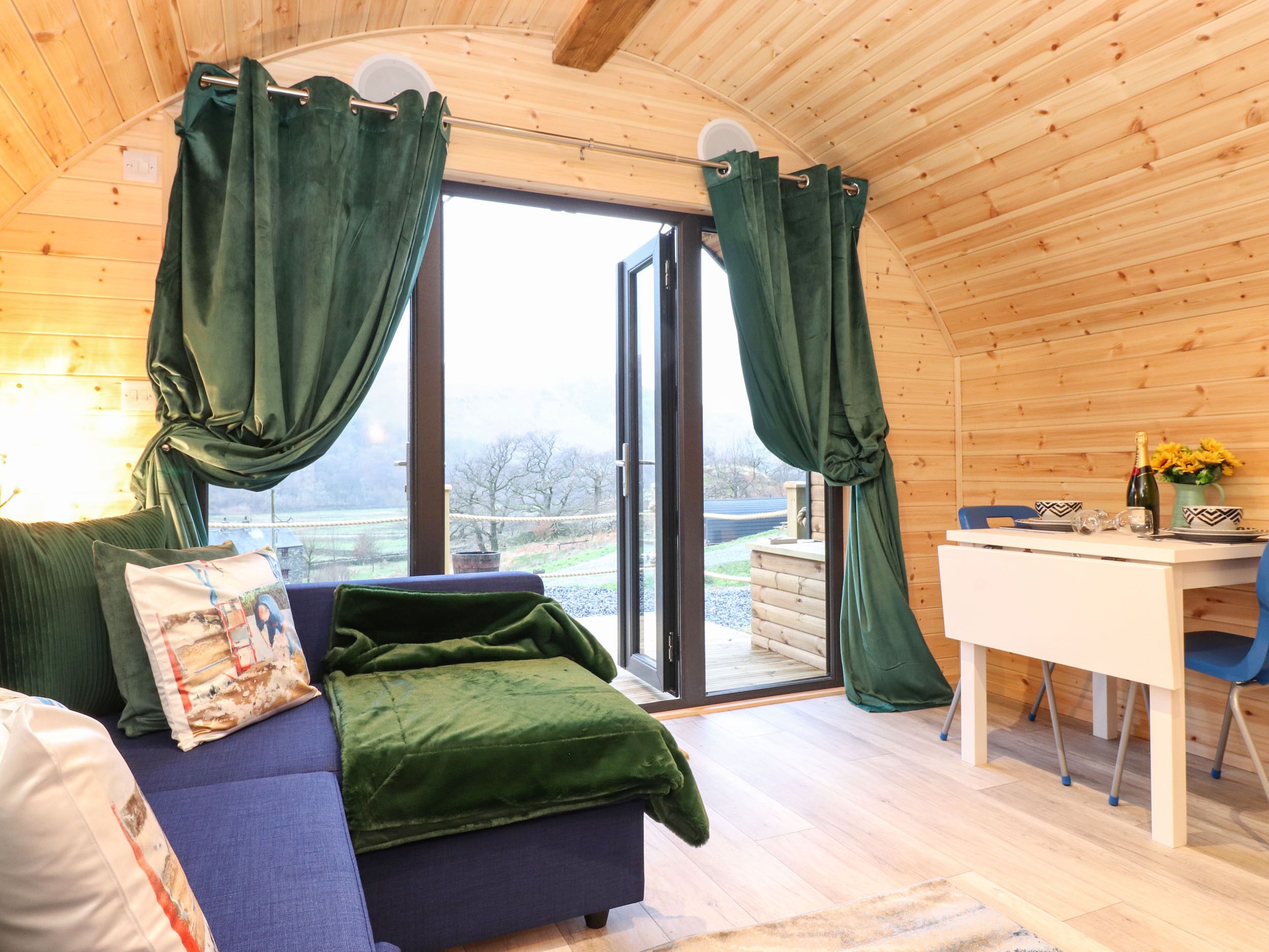 A cozy room with a sofa, a dining table, and curtains.