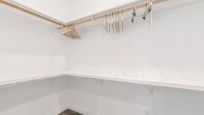 A white room with a wooden beam ceiling, a clothes rack, and a power outlet on the wall. - Charming Cottage -3BR - A+ Location - est.2019 (Lafayette)