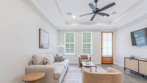 A living room with a sofa, armchairs, a coffee table, and a TV. - Charming Cottage -3BR - A+ Location - est.2019 (Lafayette)
