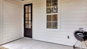 A house with a dark door, a window with blinds, and a barbecue grill outside. - Charming Cottage -3BR - A+ Location - est.2019 (Lafayette)