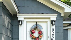 A white front door with a wreath, a mailbox, and a house number. - Newly Remodeled 3BR in Town · Cherry Street (Van Buren)