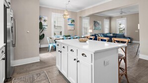 A spacious kitchen with a central island, white cabinetry, and a modern pendant light. - Close to Beach | Golf Cart | Heated Pool (Santa Rosa Beach)
