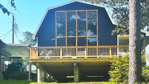 A large, single-story house with a prominent front porch and a large window. - Lakeside cottage, water access + pet friendly with additional fee (Jasper)